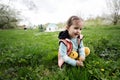 Baby girl plucking yellow flowers on spring meadow Royalty Free Stock Photo