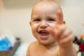 Baby girl pointing his finger straight to the camera. Cute adorable baby after bath time