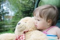 Baby girl portrait sitting in baby carriage with teddy bear toy together Royalty Free Stock Photo