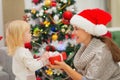 Baby girl presenting mother Christmas gift Royalty Free Stock Photo