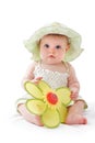 Baby girl in pretty hat plays with toy flower Royalty Free Stock Photo