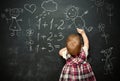 Baby girl pupil draws a chalk on blackboard Royalty Free Stock Photo