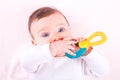 Baby girl with rattle teether toy. Royalty Free Stock Photo