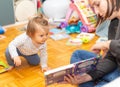 Baby. Girl. Reading. Book. Mother. Joy. Cute Royalty Free Stock Photo