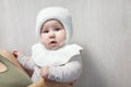 Baby girl ready to go for a walk with warm woolen hat, mother dresses a little child