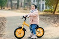 Baby girl rides a bicycle outdoors at the park. Little kid enjoying a happy childhood at warm spring day. Royalty Free Stock Photo