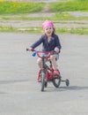 Baby girl riding her bike on the school Playground.