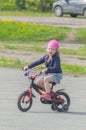 Baby girl riding her bike on a Sunny day.