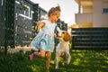 Baby girl running with beagle dog in backyard in summer day. Domestic animal with children concept Royalty Free Stock Photo