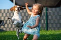 Baby girl running with beagle dog in garden on summer day. Domestic animal with children concept Royalty Free Stock Photo