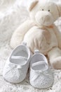 Baby girl shoes and teddy bear Royalty Free Stock Photo