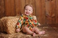 Baby Girl Sitting Against a Straw Bale Royalty Free Stock Photo