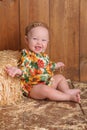 Baby Girl Sitting Against a Straw Bale Royalty Free Stock Photo