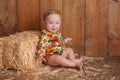 Baby Girl Sitting Against a Straw Bale Royalty Free Stock Photo