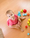 Baby sitting on chamber pot and playing with toys. Top view. Royalty Free Stock Photo