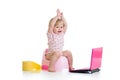 Baby girl sitting on chamberpot with notebook Royalty Free Stock Photo