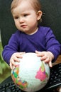 Baby girl sitting with computer keyboard and a globe