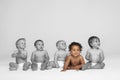 Baby girl sitting on floor with other babies looking away Royalty Free Stock Photo