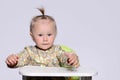 Baby girl sitting on a high chair ready to eat. Royalty Free Stock Photo