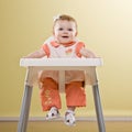 Baby girl sitting in highchair waiting to be fed Royalty Free Stock Photo