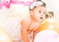 Baby Girl Sitting With Pillows and Balloons