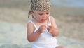 Baby girl sitting and playing on the beach
