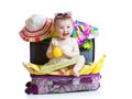 Baby girl sitting in suitcase with things for Royalty Free Stock Photo