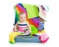 Baby girl sitting in suitcase with things for Royalty Free Stock Photo