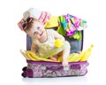 Baby girl sitting in suitcase with things for vacation travel Royalty Free Stock Photo