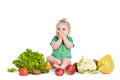 Baby girl sitting surrounded by fruits and vegetables, isolated on white Royalty Free Stock Photo