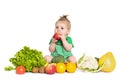 Baby girl sitting surrounded by fruits and vegetables, isolated on white Royalty Free Stock Photo