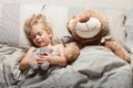 Baby girl sleep in bed, toddler dream. Child with teddy bear. Comfort home relax