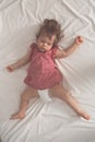 Baby girl sleeping on back with open arms and without pacifier in a bed with white sheets. Peaceful sleeping in a bright Royalty Free Stock Photo