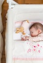 Baby girl sleeping in a cot with pacifier and toy Royalty Free Stock Photo