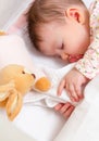 Baby girl sleeping in a cot with pacifier and toy Royalty Free Stock Photo