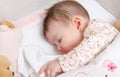 Baby girl sleeping in a cot with pacifier and toy Royalty Free Stock Photo