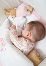 Baby girl sleeping in a cot with pacifier and toy Royalty Free Stock Photo