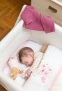 Baby girl sleeping in a cot with pacifier and toy Royalty Free Stock Photo