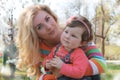 Baby girl smelling magnolia blossom with mother in spring Royalty Free Stock Photo