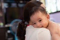 Baby girl is smile, she resting on mother`s shoulder. mom embracing baby girl in her arms Royalty Free Stock Photo