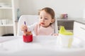 Baby girl with spoon eating puree from jar at home Royalty Free Stock Photo