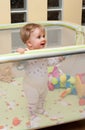 Baby girl stand in playpen