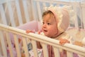Baby girl standing in her crib. Royalty Free Stock Photo