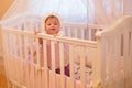 Baby girl standing in her crib. Royalty Free Stock Photo