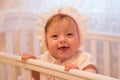 Baby girl standing in her crib. Royalty Free Stock Photo