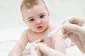 Baby girl is starring on syringe with vaccine Royalty Free Stock Photo