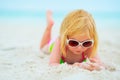 Baby girl in sunglasses laying on beach Royalty Free Stock Photo