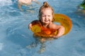 Baby girl swimming in a pool. Water park. Summer holiday activities. Cute funny toddler girl in relaxing on Royalty Free Stock Photo
