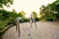 Baby girl swing in children`s playground toy set in public park Royalty Free Stock Photo