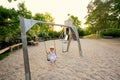 Baby girl swing in children`s playground toy set in public park Royalty Free Stock Photo